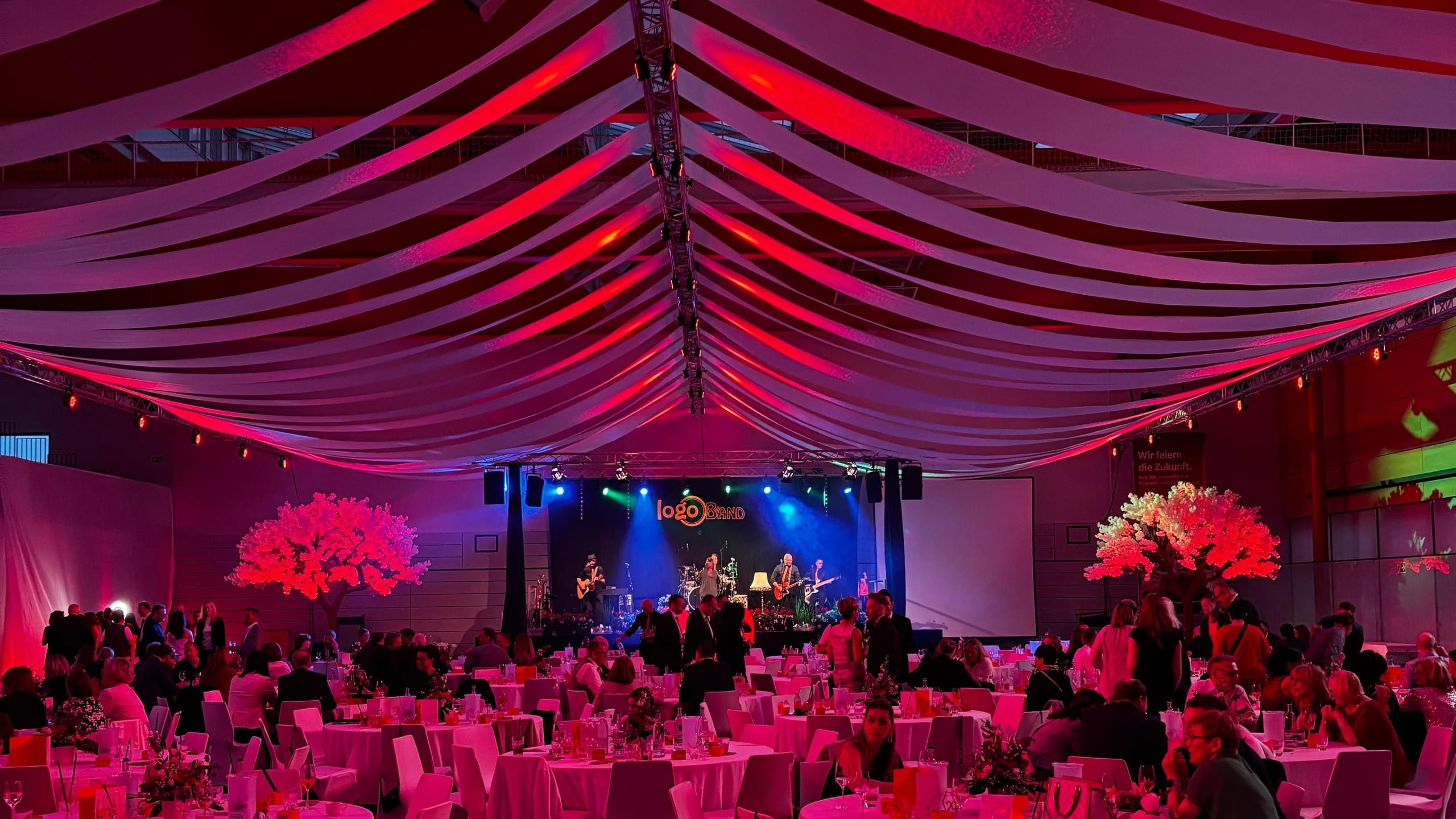 Festlich beleuchtete Gala in einer geschmückten Halle mit Bühne